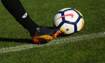 Football player kicking Premier League ball.